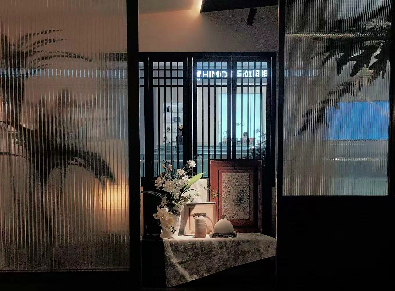 西町村屋门店内带有压纹玻璃、花艺与装裱画的空间陈列